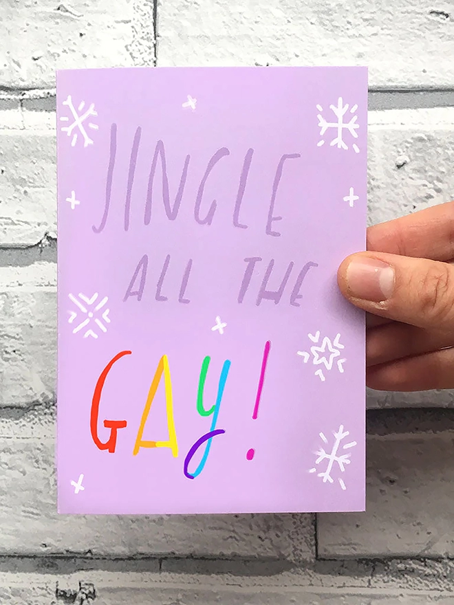 Vibrant purple card held in front of brick wall