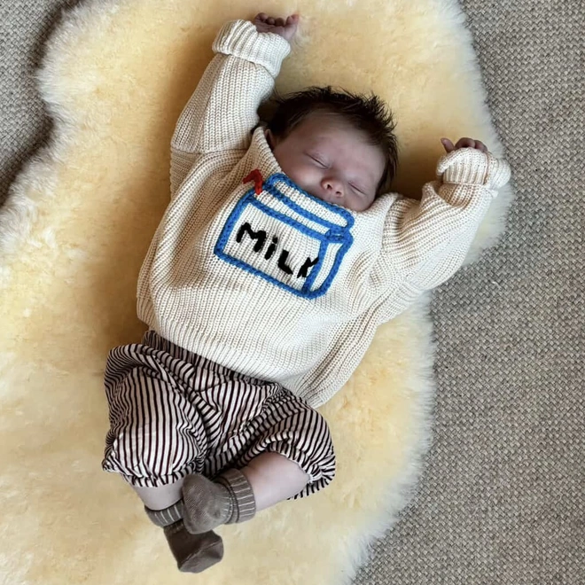 Knitted baby grow jumper for babies with a milk carton embroidered on the front