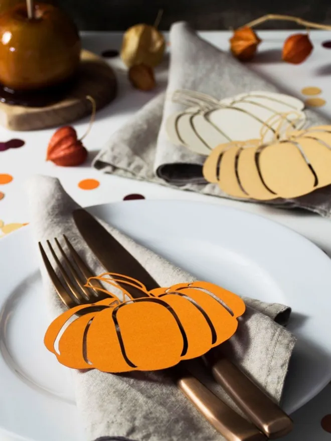 Orange and Cream Pumpkin table decorations displayed on a table decorated with confetti and toffee apples