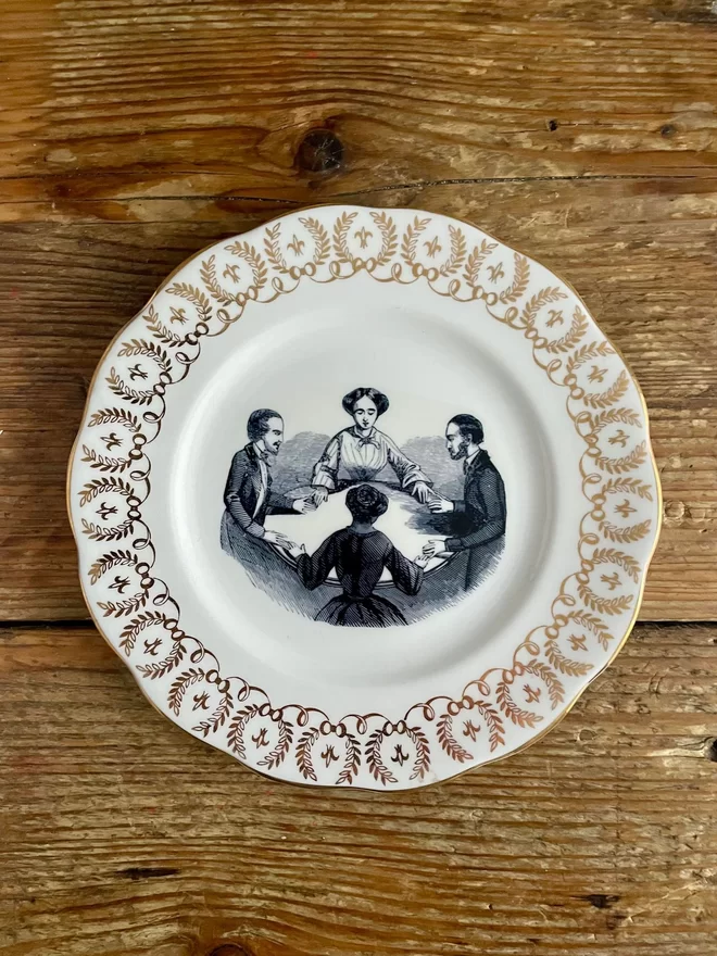 vintage plate with an ornate border, with a printed vintage illustration of a seance in the middle