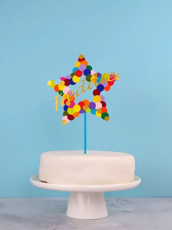 Personalised Name Cake Topper. Rainbow coloured star with gold name "freddie"  across the centre