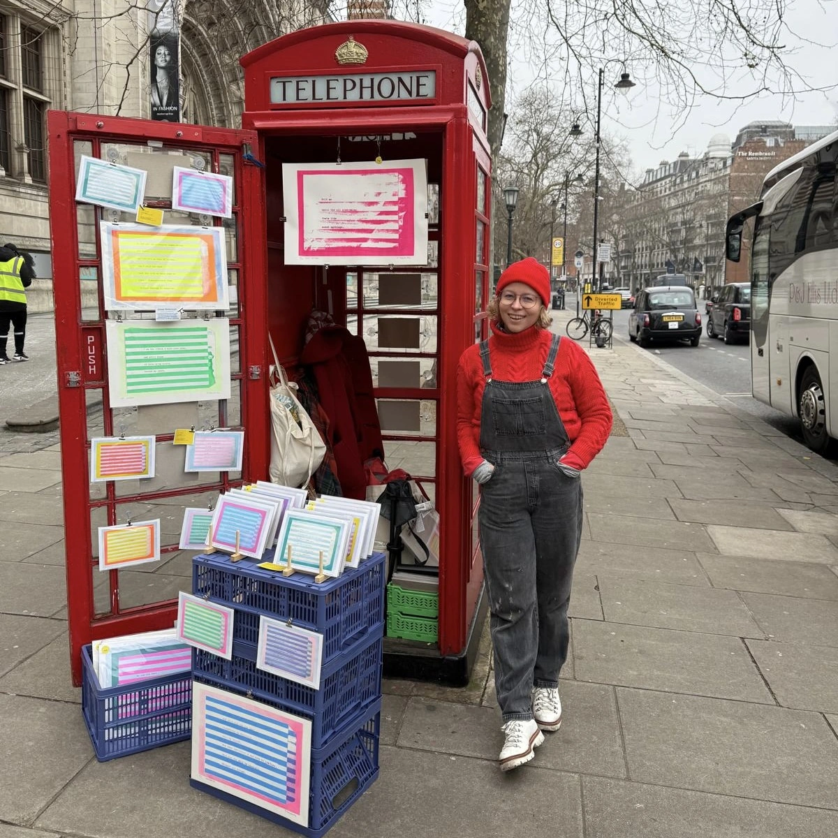 Emily standing next to red London Telephone Box outside V&A with Sweet Nothings Prints