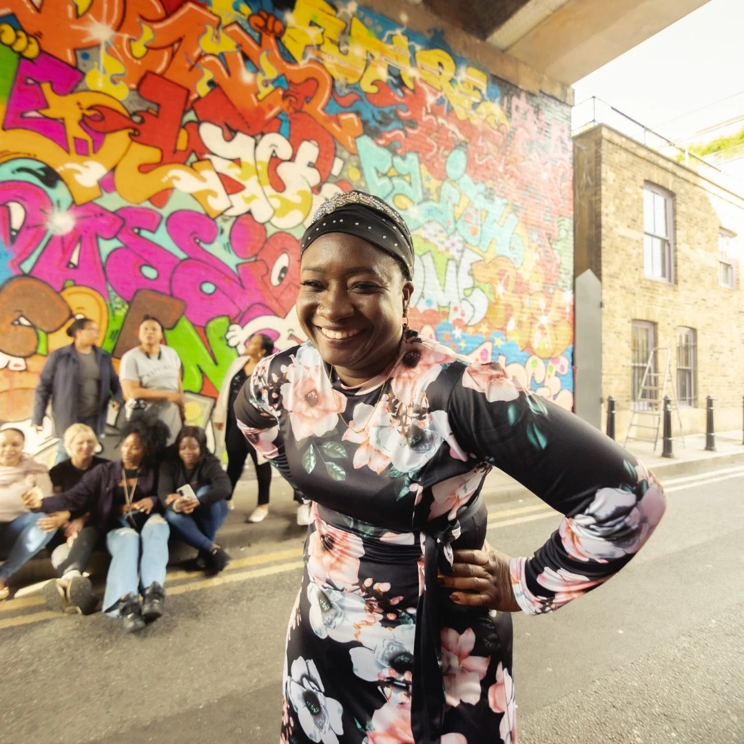 staff member in front of colourful graffiti 