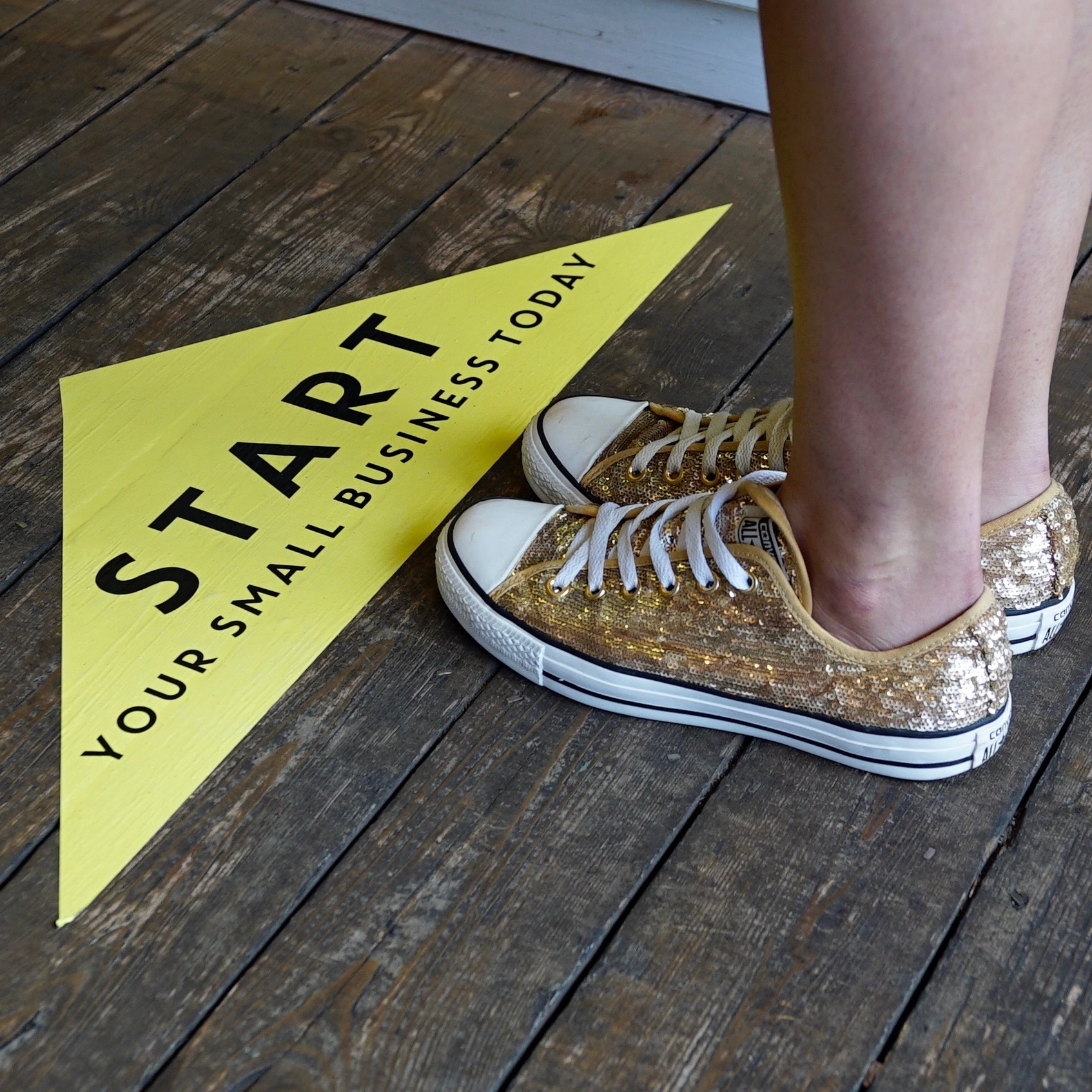 Start your small business today yellow floor sticker and gold trainers