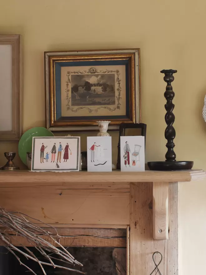 row of joyful illustrated christmas cards on a mantlepiece