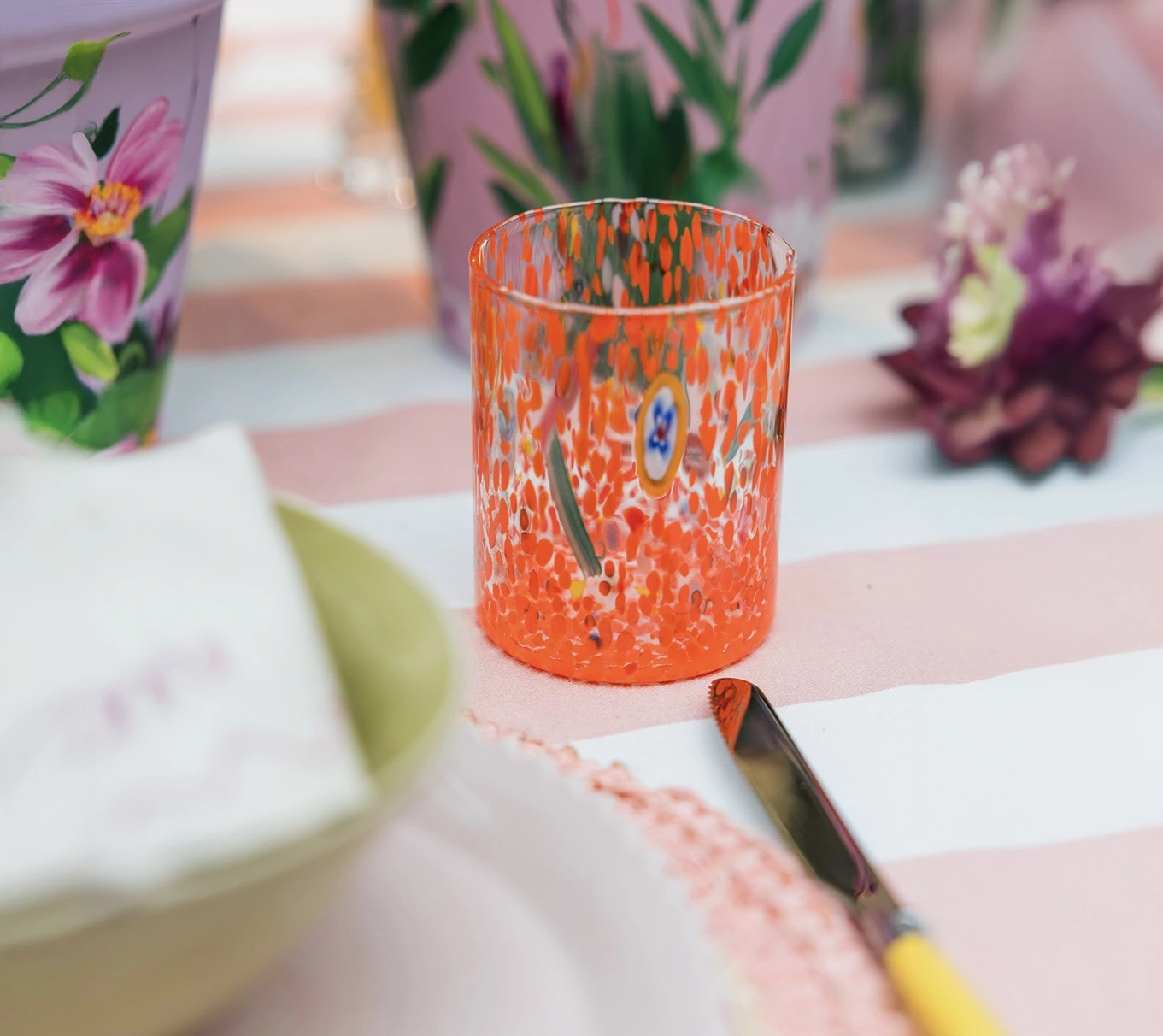 Hand blown orange glasses on a spring table setting