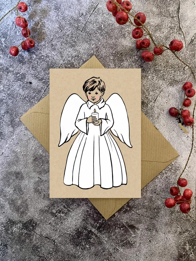 greeting card featuring a boy angel holding a candle with a Kraft envelope