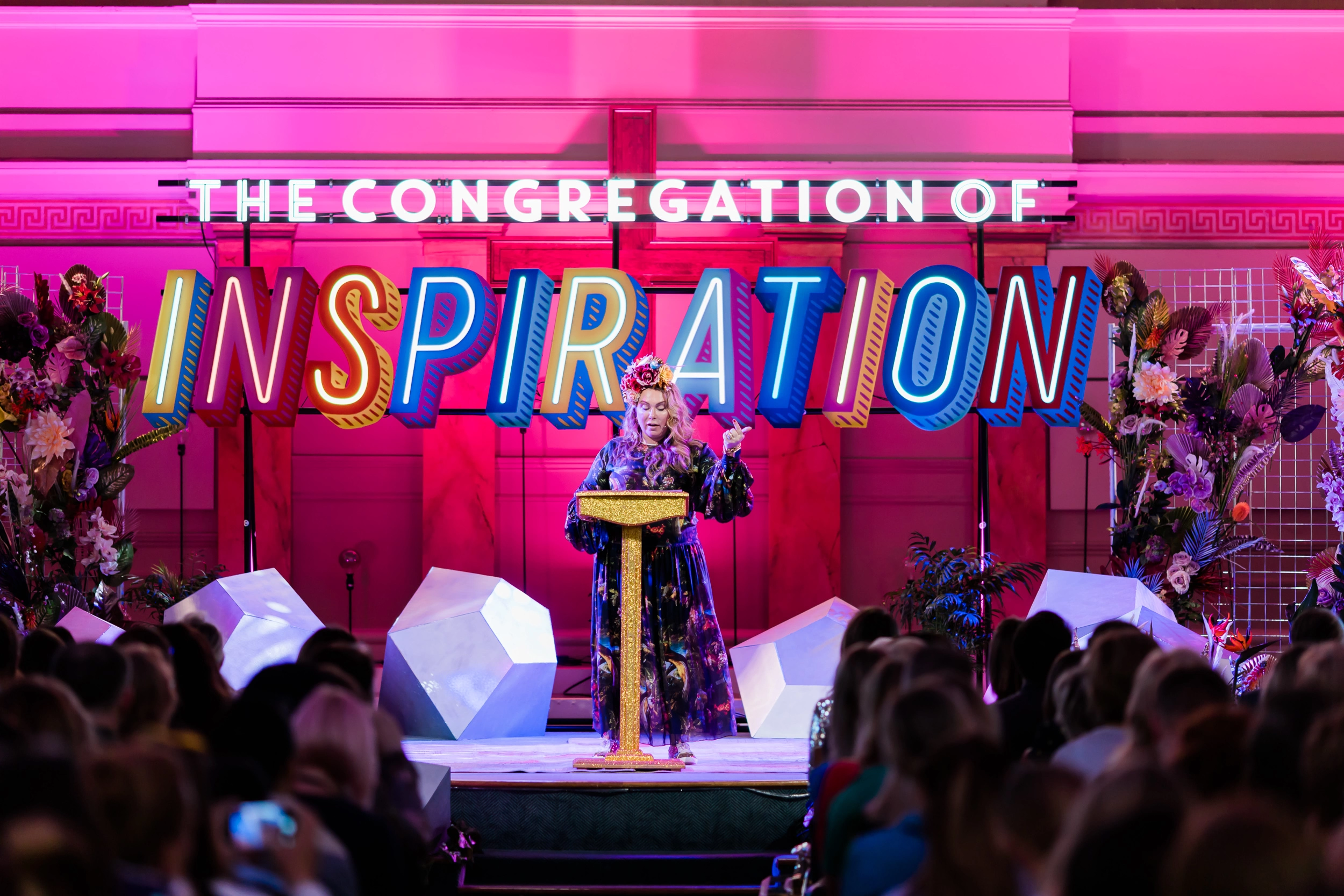 Holly Tucker MBE standing on stage at her event, Congregation of Inspiration.