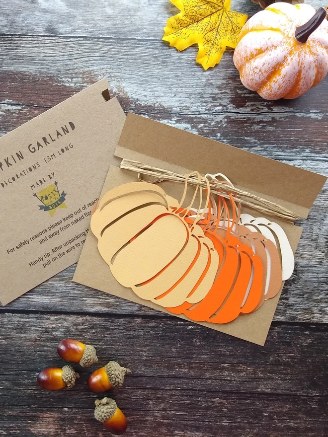 Packaging example for pumpkin garland. Decorations are wrapped around cardboard backing sheet.