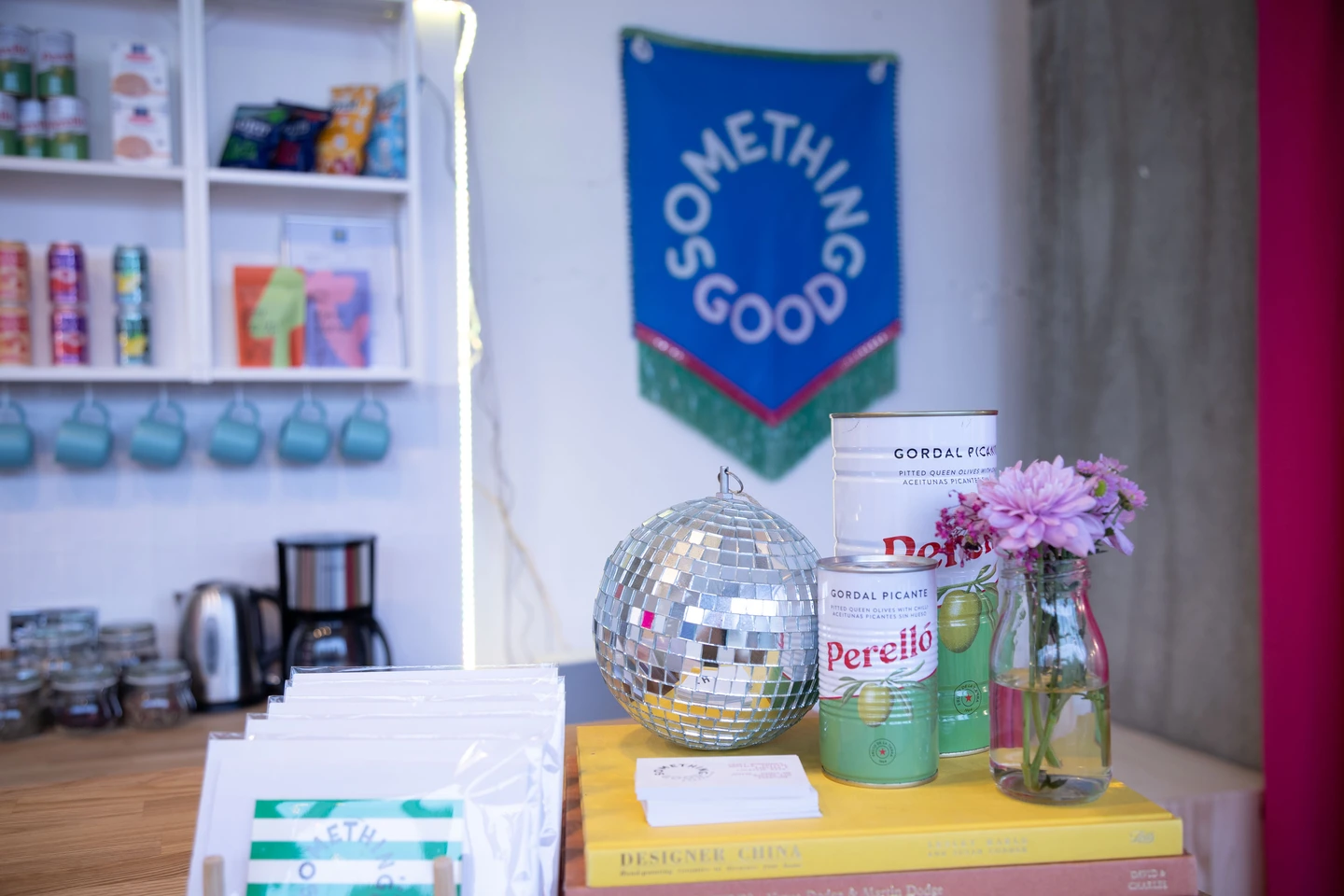 Colourful hand made banner, olives and disco ball behind bar