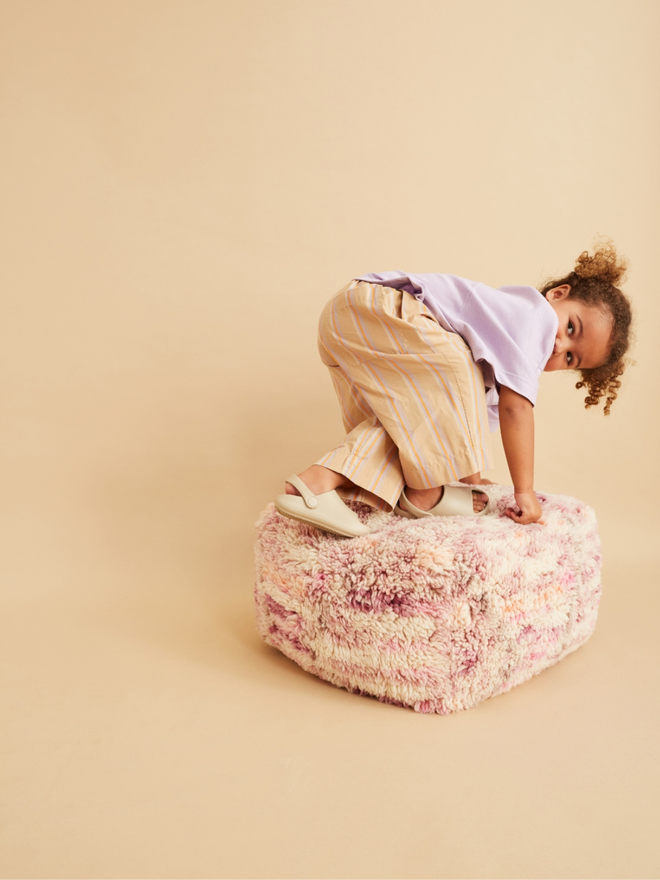 cool kid model wearing neutral korean style outfit oversized stripe trousers and lilac t-shirt