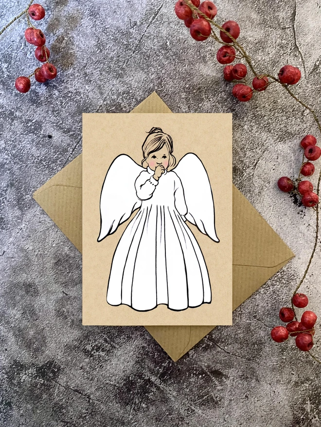 greetings card featuring a little angel sucking her thumb with Kraft envelope