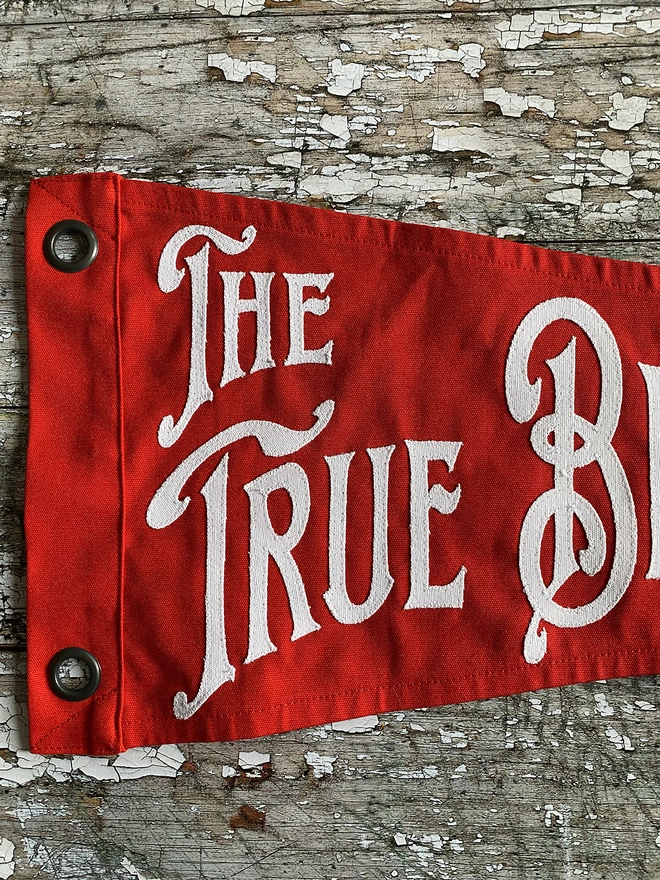 Detail of a red The true believers pennant flag
