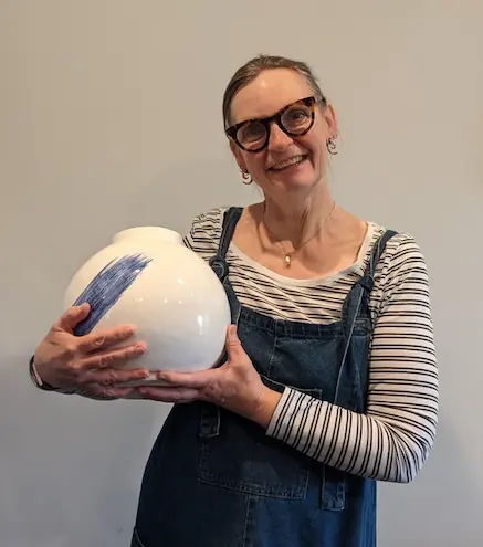 Ysanne Brooks holding a blue and white ceramic moon jar
