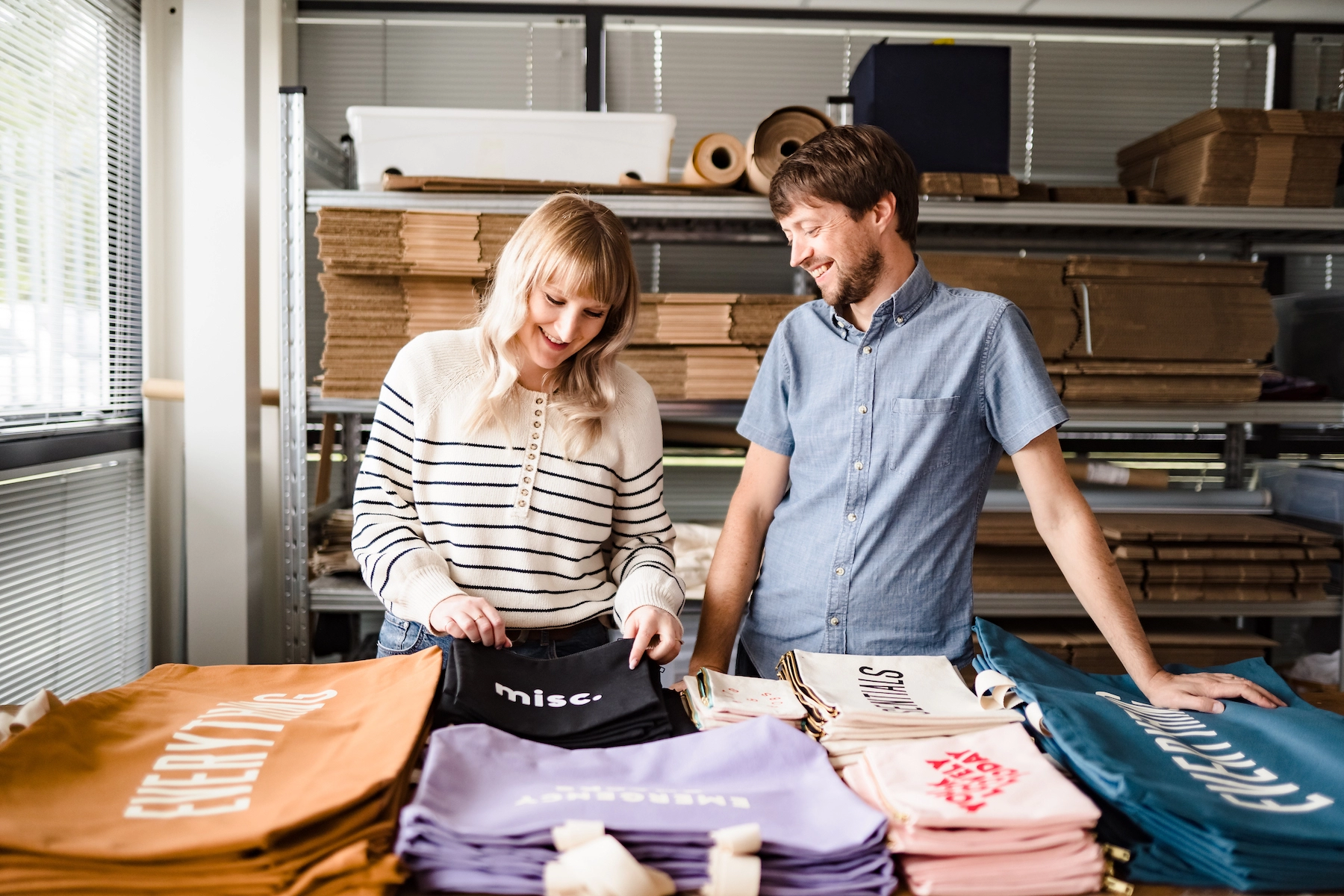 Hayley and Lucas, founders of Alphabet Bags, inspecting bags in their studio