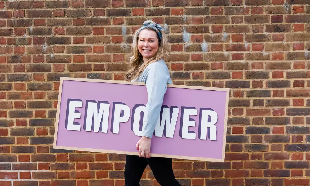 Holly with an 'Empower' sign by Modo & Co