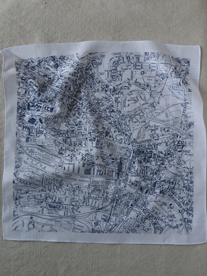 Mr.PS Glasgow map handkerchief laid flat on a linen tablecloth