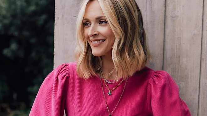 Fearne Cotton, founder of Happy Place, smiling into the distance in a pink top.