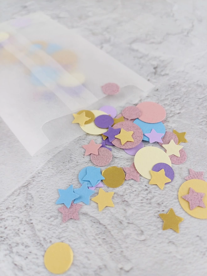 Closeup of confetti which features 5 pointed stars, large 1.5cm and small 1cm circles
