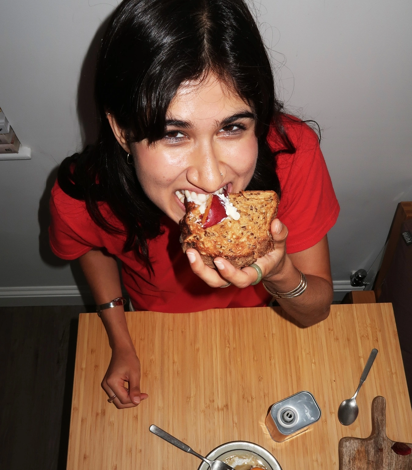yasmin eating a piece of toast and smiling up into the camera