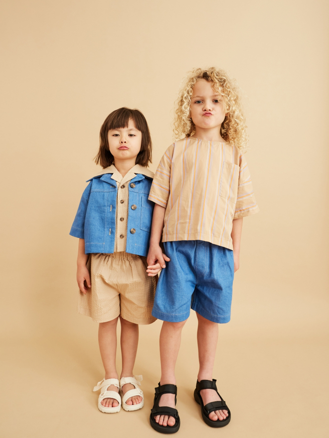 pair of kids wearing super kool japanese style clothing in organic denim and beige. both are oversized and very stylish