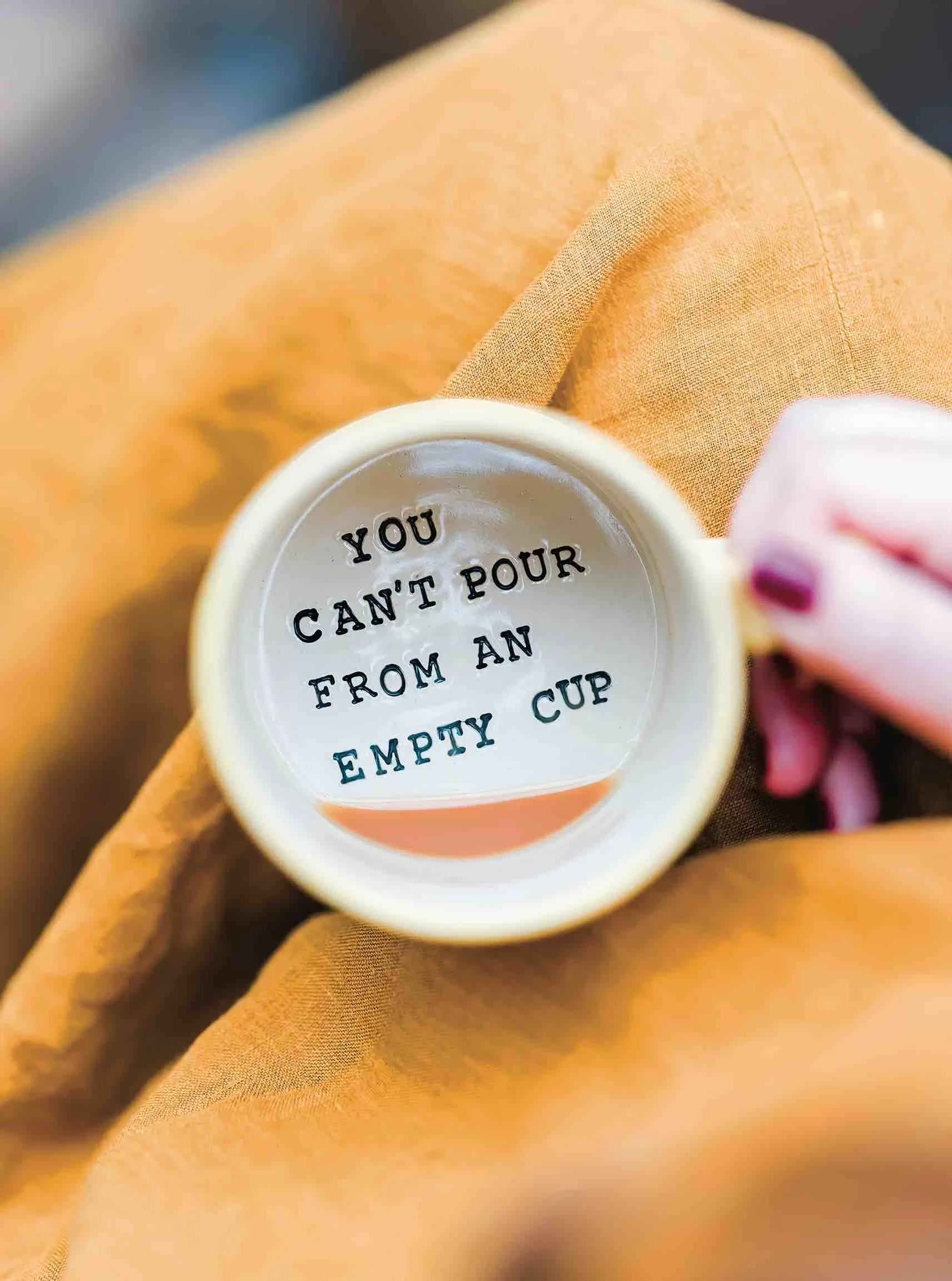 Zara ceramic mug with the phrase you can't pour from an empty mug stamped inside.