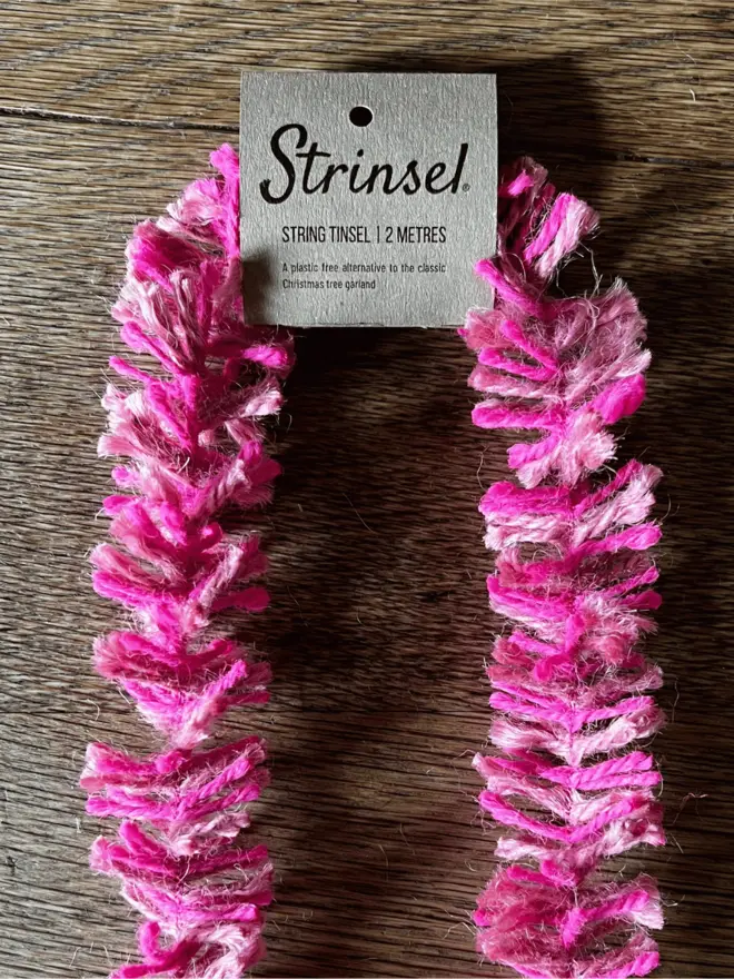 Pink Pop Strinsel with label AKA Jute string tinsel on an oak table