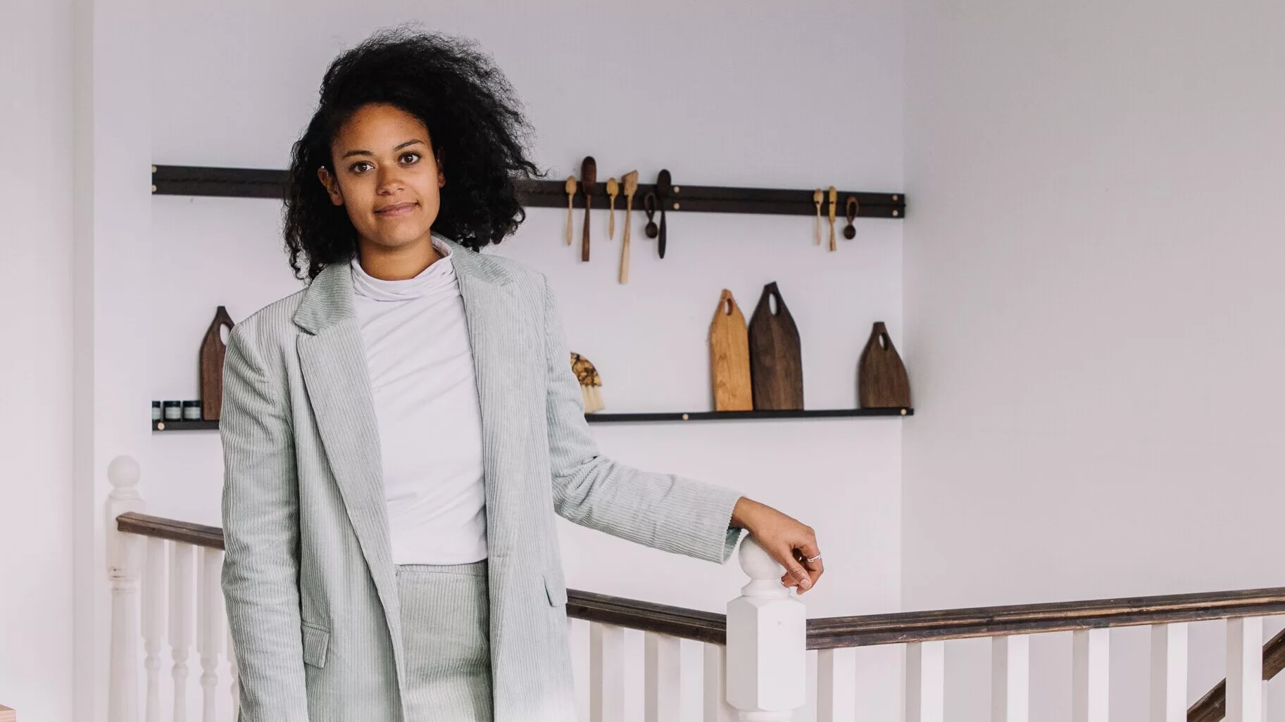 Sophie Sellu, founder of Grain & Knot, smiling at the camera wearing a grey suit.