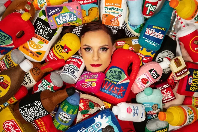 Lucy Sparrow, founder of Sew Your Soul, looking at the camera, surrounded by Sew Your Soul products.