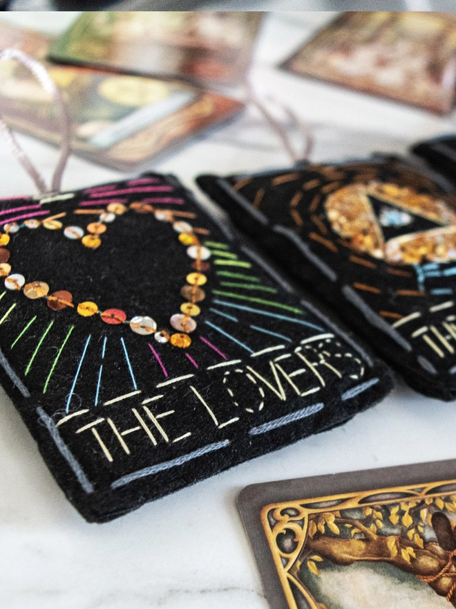 Handcrafted felt ornaments with sequins and embroidery depicting "The Magician”, “The Empress” and “The Lovers”