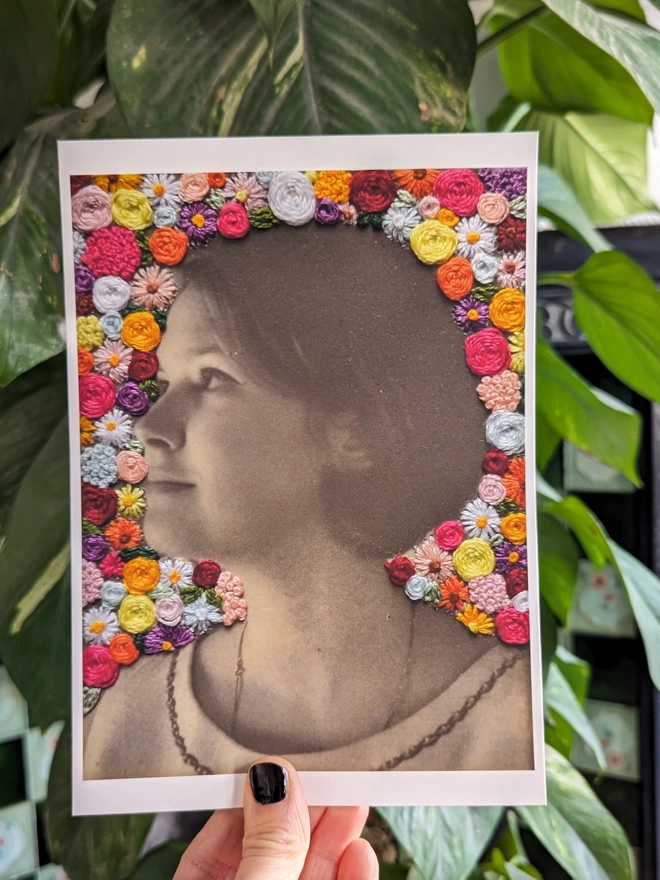 Vintage photo of lady surrounded by embroidered flowers print held against plant