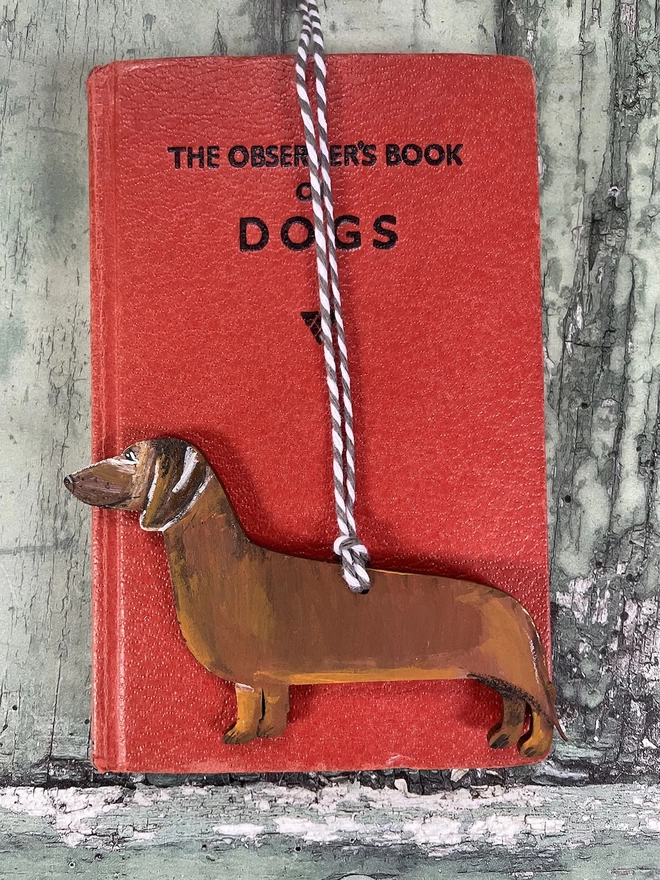 Red Dachshund Hand-painted Memorial Keepsake placed on a book about dogs