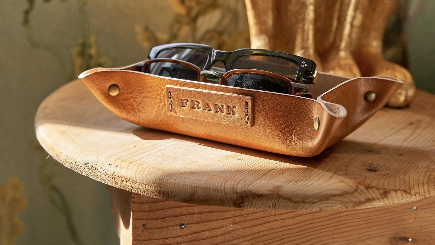 Personalised leather coin tray. A personalised coin tray hand-stamped with a name on the front
