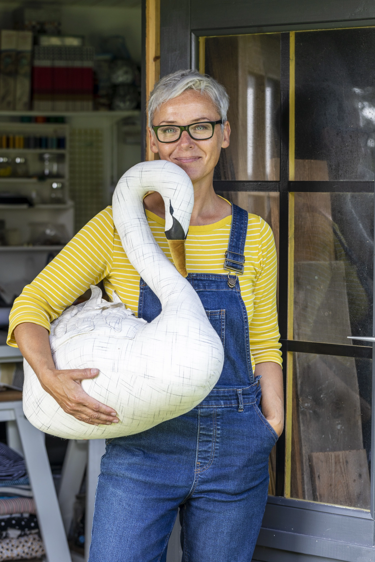 Manda McGrory stood in the doorway of her studio, holding a fabric swan