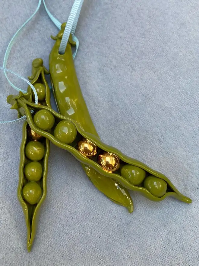 handmade ceramic peas in a pod christmas decoration with two gold peas