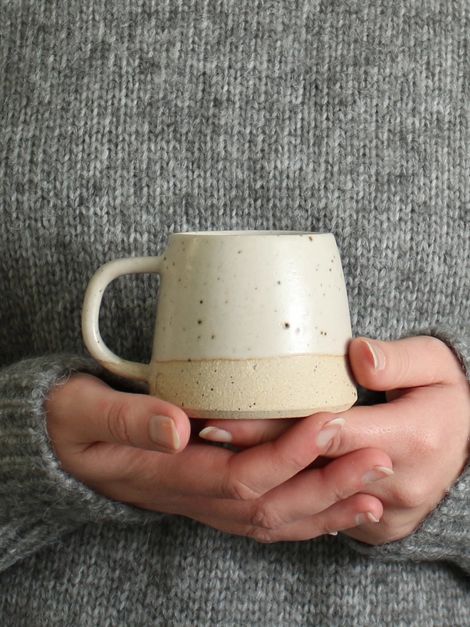 small white mug being held