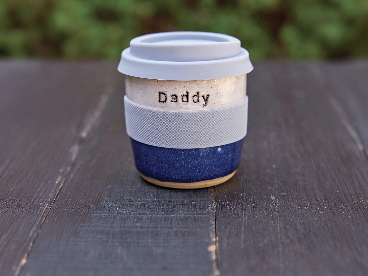 Personalised stamped ceramic travel mug. A ceramic blue travel mug stamped with the word 'daddy'