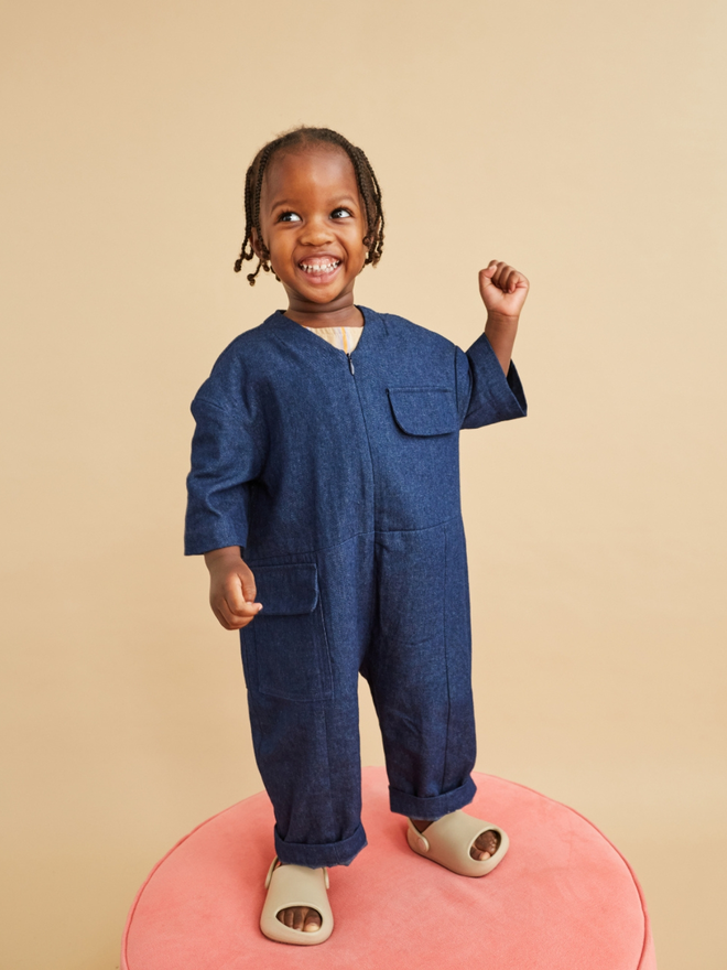 cool baby kidswear oversized kids and toddler denim overalls standing on pink stool from pavement store walthamstow 