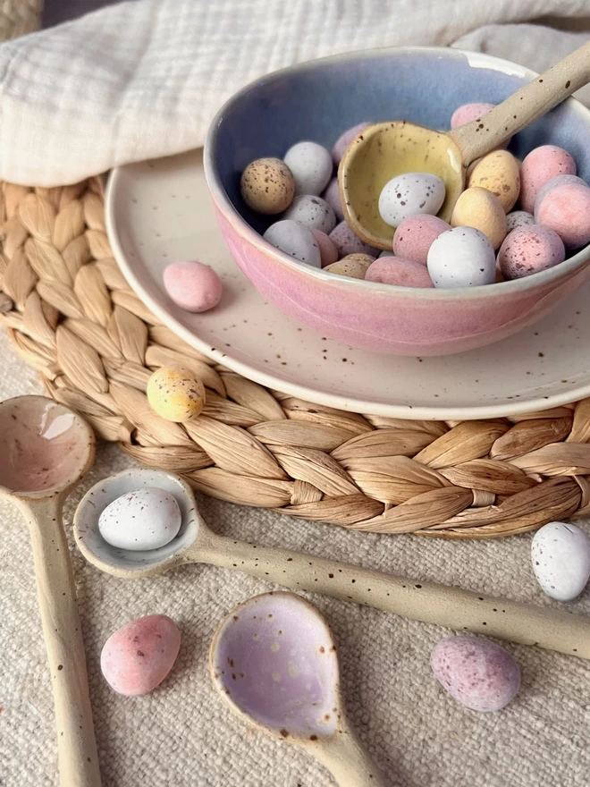 mini egg spoons beside a bowl of chocolate mini eggs