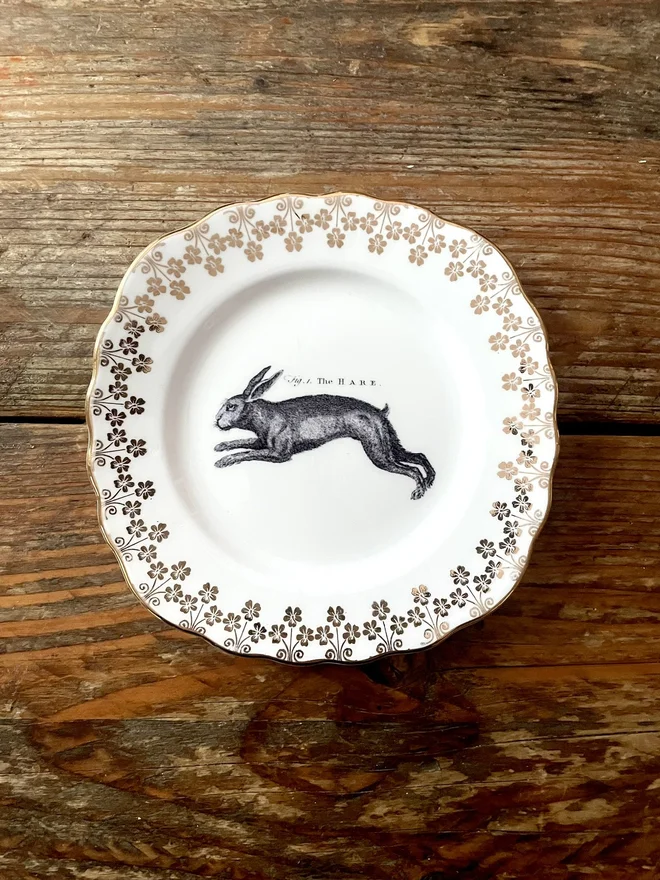 vintage plate with an ornate border, with a printed vintage illustration of a hare in the middle 
