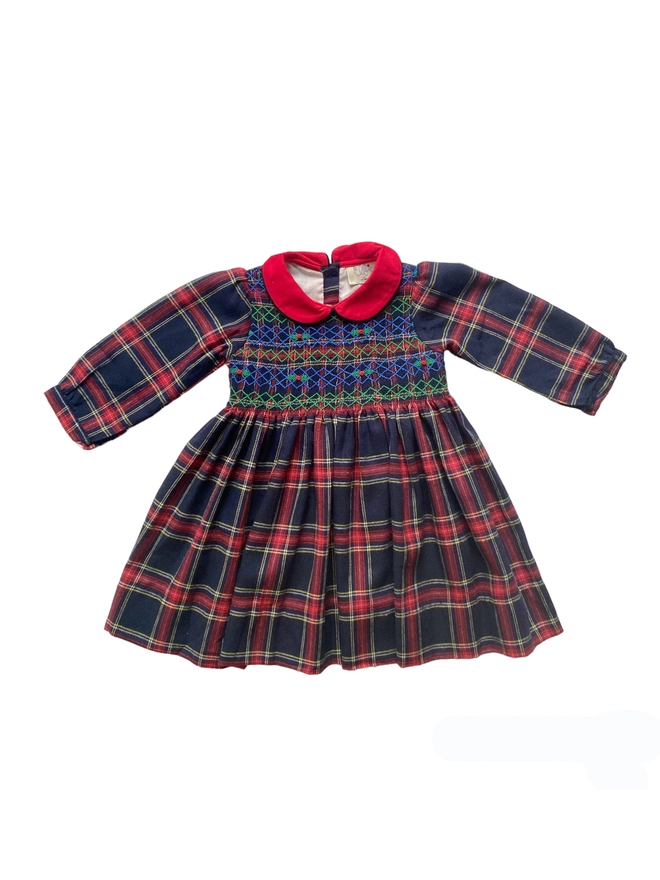 A navy and red tartan dress with a red collar and hand smocking