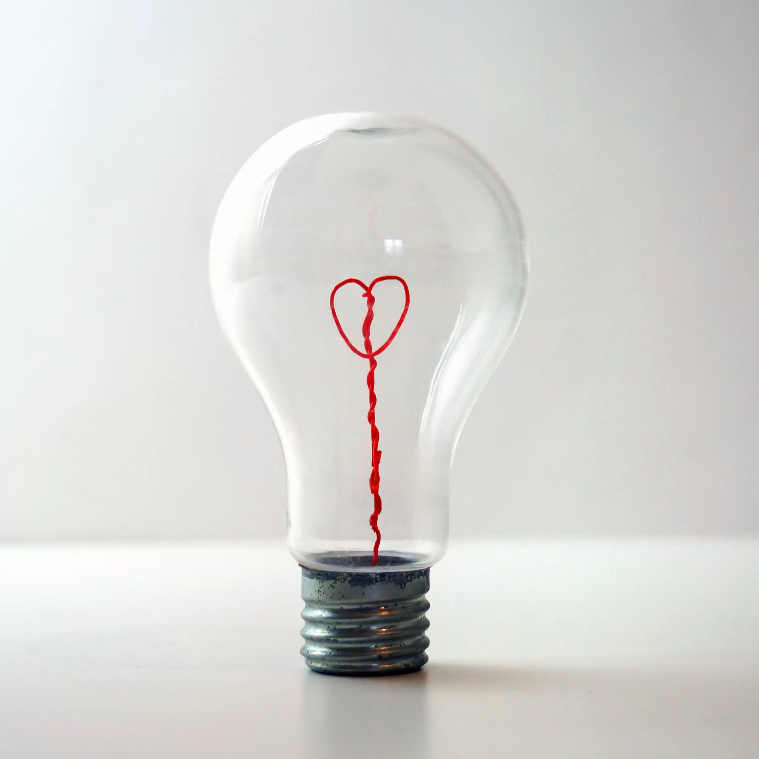 Red wire heart inside a lightbulb