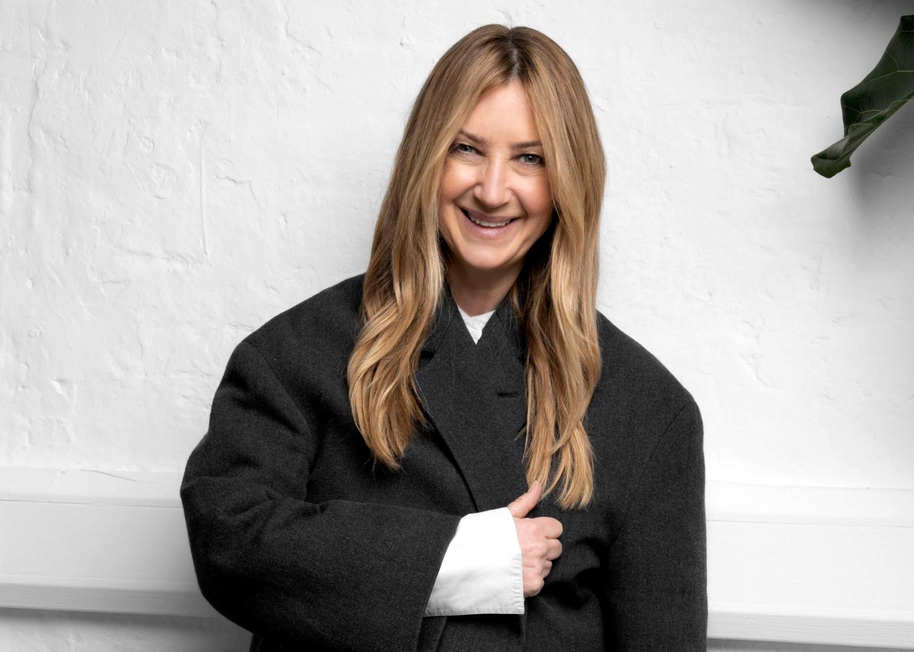 Anya Hindmarch CBE, founder of Anya Hindmarch, smiling at the camera wearing a black coat.