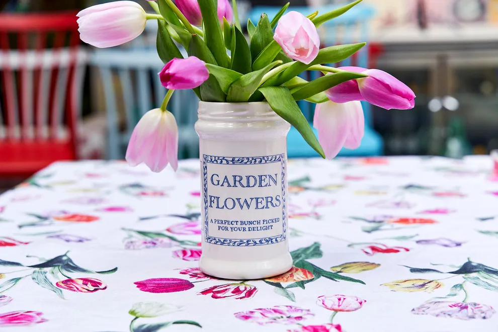 Garden flowers vase. A ceramic vase with an illustration in blue saying garden flowers on the front