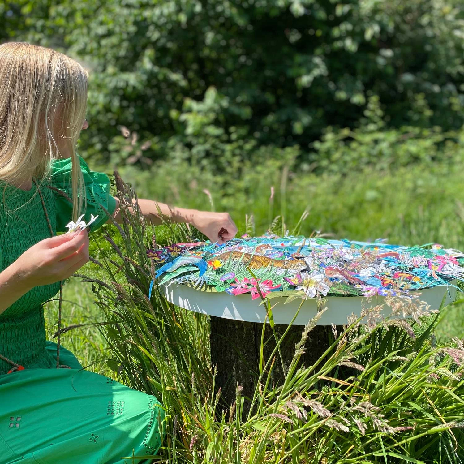Kristjana pinning one of her 3d original artwork in gunnesbury park for a photoshoot