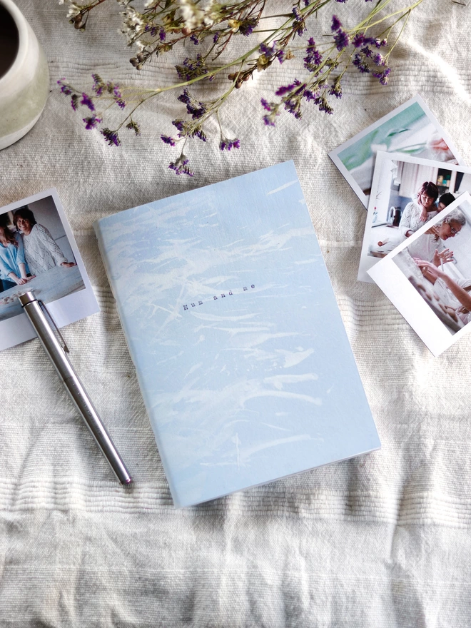 Soft blue journal with white brushed design and the words 'mum and me' typed on the cover