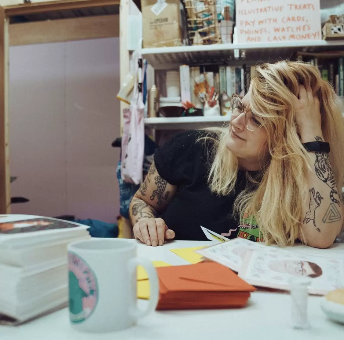 Nicola Fernandes in her studio in Manchester, Islington Mill surrounded by stacks of her work, illustrated products and greeting cards