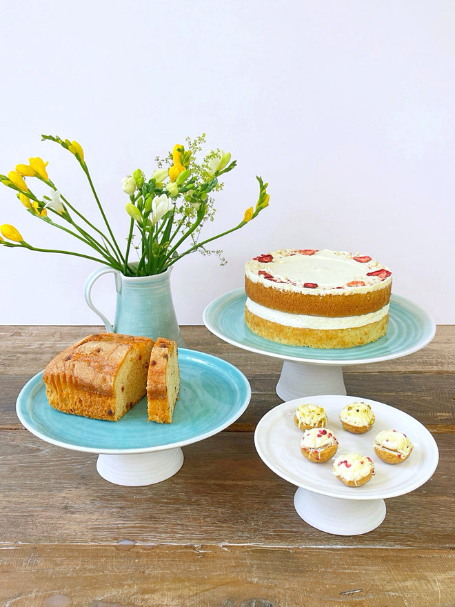 trio of cake stands with cakes on rustic table top