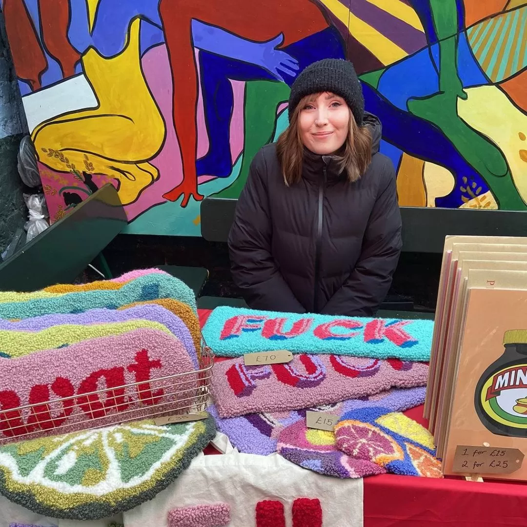 Immy's Rugs storefront image at a market.