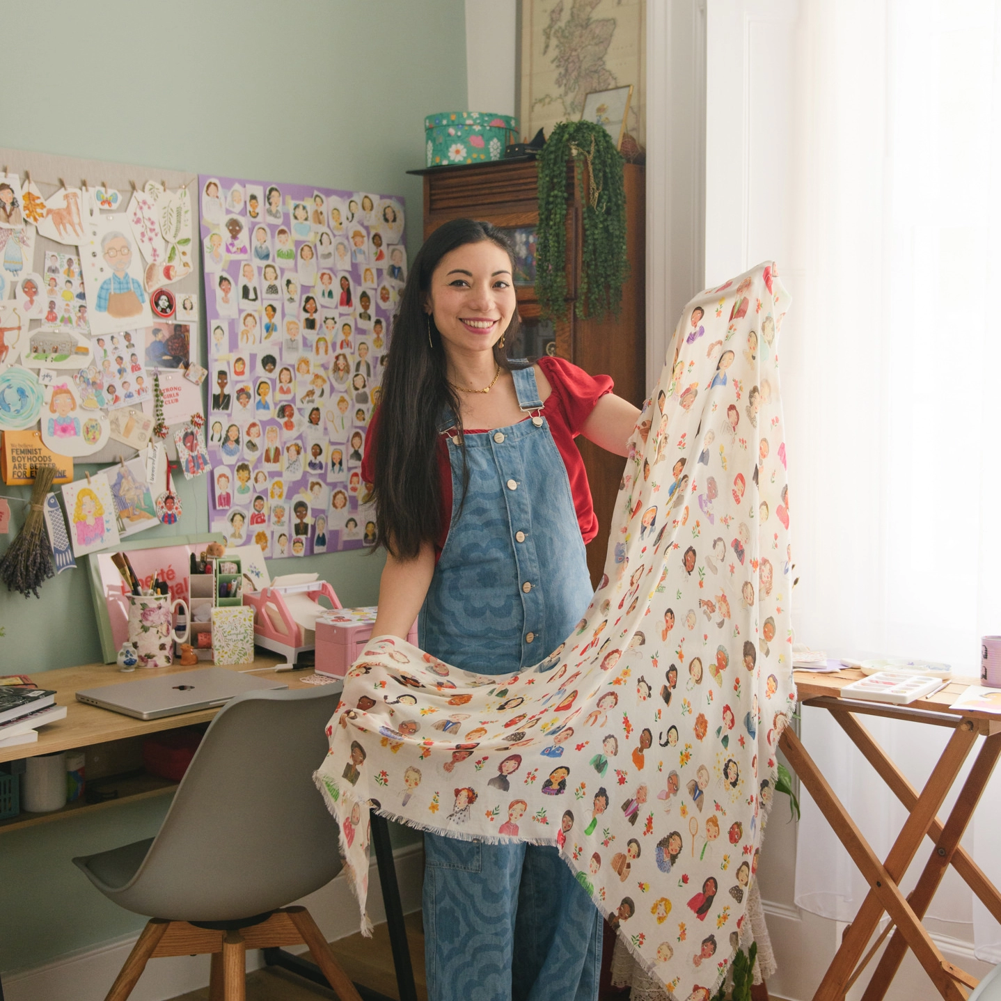 Eilidh designer of Book of Deer standing in her studio holding an iconic women blanket